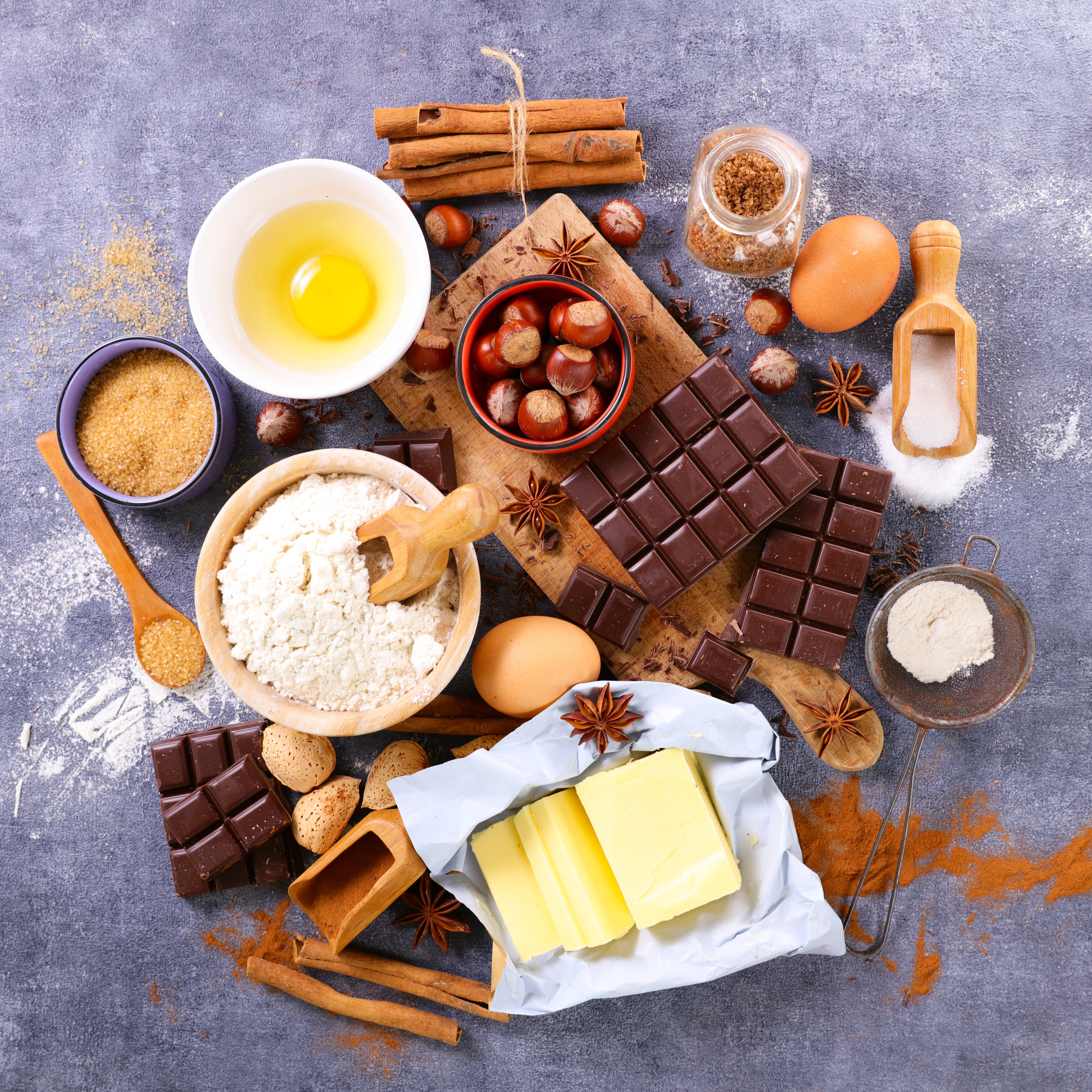 Ingredients for baking: flour, sugar, chocolate, butter, eggs, nuts, and spices.